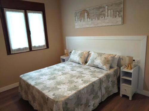 a bedroom with a large bed and two windows at Apartamentos Turísticos El Collau in La Robellada de Onis