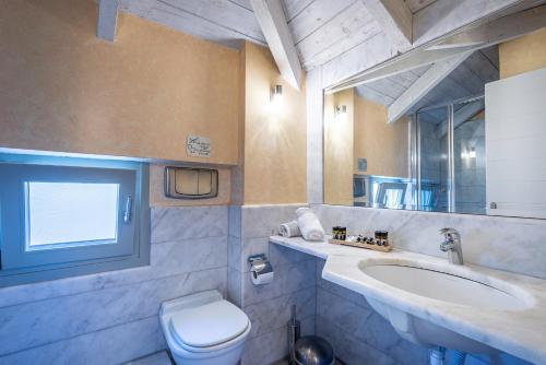 a bathroom with a toilet and a sink at Harmony Hotel Apartments in Selianitika