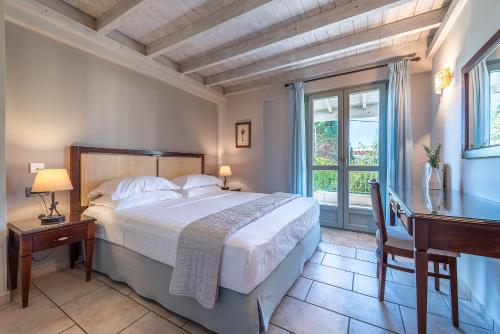 a bedroom with a bed and a desk and a window at Harmony Hotel Apartments in Selianitika