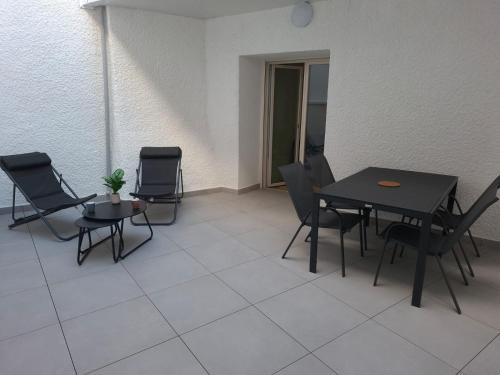 a patio with chairs and a table and a table and chairsktop at F2 neuf grande terrasse chemin de Stevenson proche Le Puy in Coubon