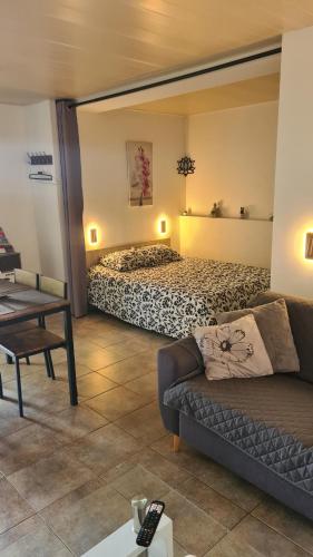 a living room with a bed and a couch at La lisière tarnaise in Labastide-de-Lévis