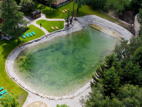 an overhead view of a large pool of water with chairs at SEINZ Wisdom Resort - Bio-Hotel vegan-vegetarisch in Bad Kohlgrub