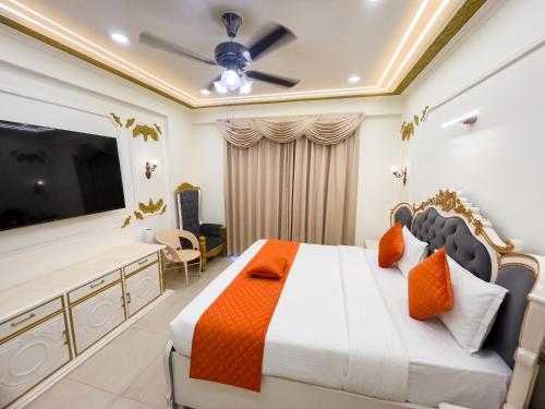 a bedroom with a large bed and a flat screen tv at Hotel Om Sai Villa Gomti Nagar, Lucknow in Lucknow