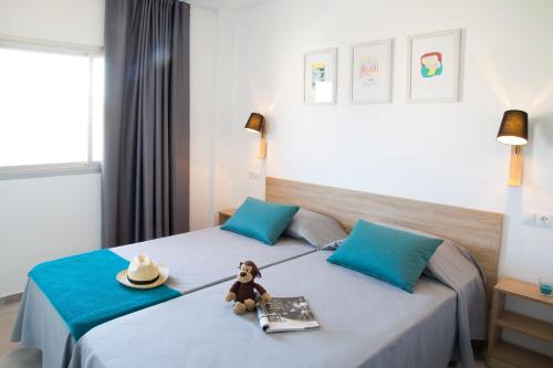 a hotel room with a teddy bear sitting on a bed at RVHotels Estartit Confort in L'Estartit