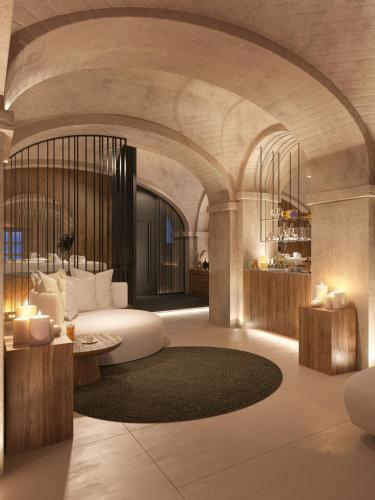 a living room with a large white bed and a table at BORGO MONCHIERO HERITAGE by Atmosphere in Monchiero