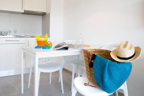 a kitchen with a white table with a hat on it at RVApartaments Estartit Confort in L'Estartit