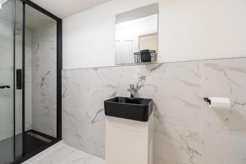 a bathroom with a sink and a shower at New 3 Bedroom Apartment Next to Station in Chepstow