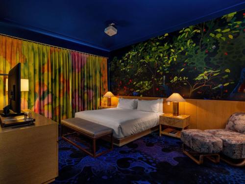 a bedroom with a bed and a painting on the wall at 21c Museum Hotel Bentonville - MGallery in Bentonville