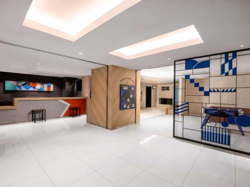 a lobby with white tile floors and a skylight at ibis Budget Osaka Umeda in Osaka