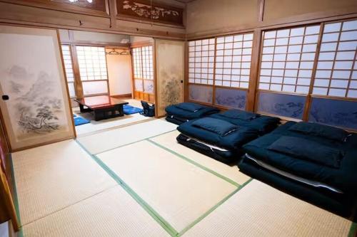 a room with two beds in a room with windows at Kujukuri SHICHIFUKU in Hasunuma