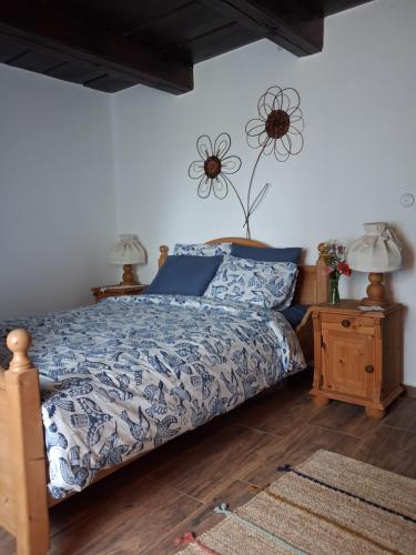 a bedroom with a bed with a blue comforter at Pacsirta Porta in Nemesnép