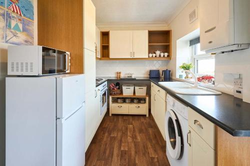 a kitchen with a white refrigerator and a sink at Host & Stay - Beachcomber Cottage Apartment in Morecambe