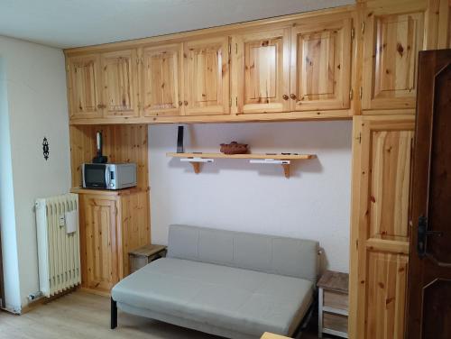 a living room with a couch and wooden cabinets at monolocale Sabrina in Torgnon