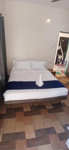 a bed with a white stuffed animal sitting on top of it at Coastal Gateway Resort in Revadanda
