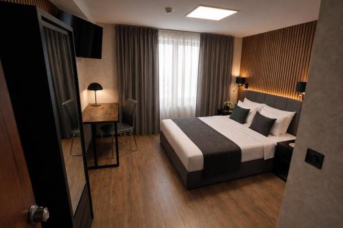 a hotel room with a bed and a desk at Edel Wellness Sleep & Spa in Gniezno