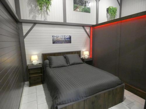a bedroom with a bed with two night stands and two lamps at Le résinier in Mimizan