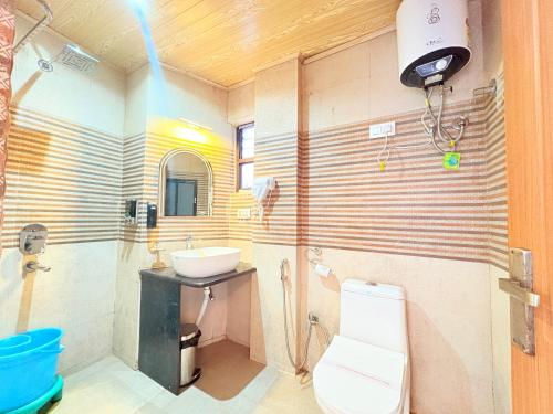 a bathroom with a sink and a toilet at The Potola Hotel And Restaurant With Parking Facility in Darjeeling