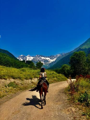 a person riding a horse down a dirt road at Beghela in Glola