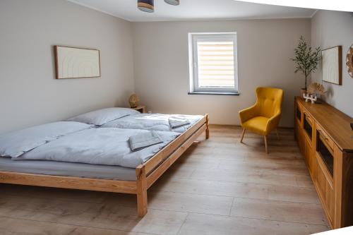 a bedroom with a bed and a desk and a chair at Przystań Hartowiec in Ostaszewo