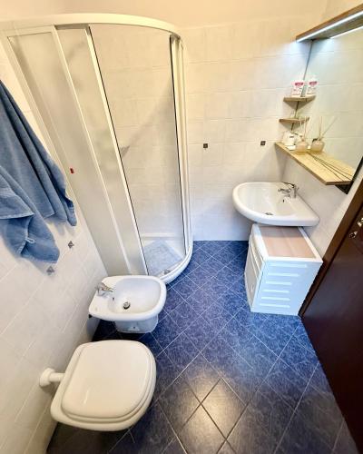 a bathroom with a toilet and a shower and a sink at San Marco Panorama Apartment in Torre deʼ Busi