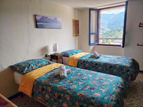 a room with two beds and a window at La Dimora di Beatrice in Santa Brigida