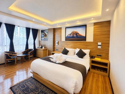 a hotel room with a large bed and a desk at The Potola Hotel And Restaurant With Parking Facility in Darjeeling
