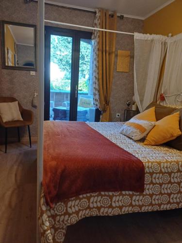 a bedroom with a bed and a large window at La Parenthèse Provençale in Cabasse