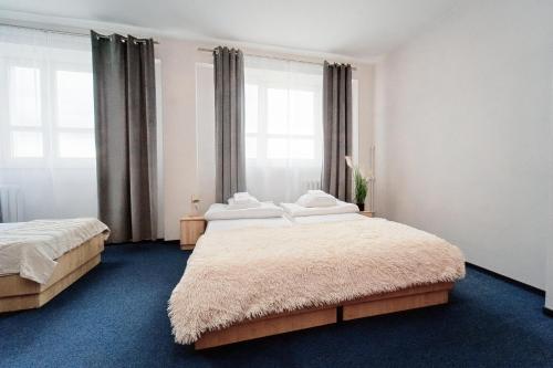 a bedroom with two beds and a large window at Sami Swoi Kutno in Kutno