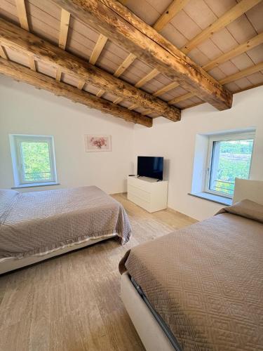 a bedroom with two beds and a flat screen tv at Vessa 3 in Selvapiana