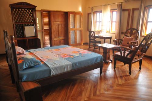 a bedroom with a bed and a table and chairs at Green Garden Lodge in Nosy Be