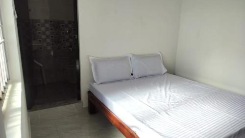 a bed with two pillows on it in a room at Sai Residency in Pallineriyanur
