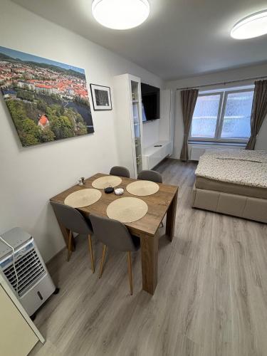 a room with a table and chairs and a bed at Apartmán 1, Heydukovka in Písek