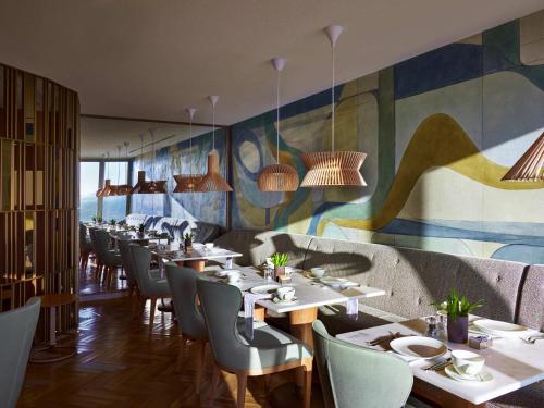 a restaurant with tables and chairs and a mural at Fairmont Rio de Janeiro Copacabana in Rio de Janeiro
