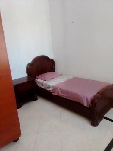 a small bed in a room with a night stand at دار المحبة - Dar El Mahabba in Tazarka