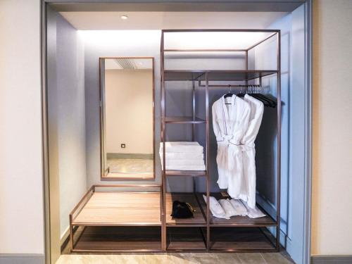a dressing room with a mirror and a robe at Mercure Xi'an Qujiang in Xi'an