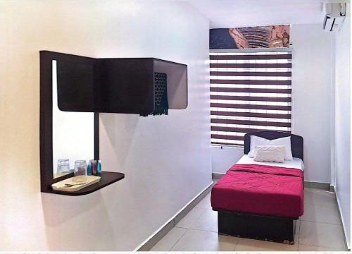 a room with a small bed and a mirror at Hotel Lii View in Mersing