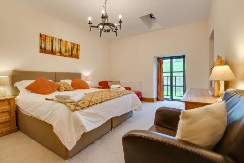 a bedroom with a large bed and a chair at 6 Bed in Machynlleth oc-bow374 in Cemmaes