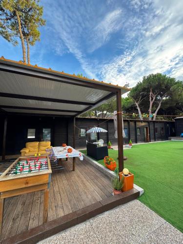 a backyard with a deck with a ping pong table at Surf Camp Ecológico in Costa da Caparica