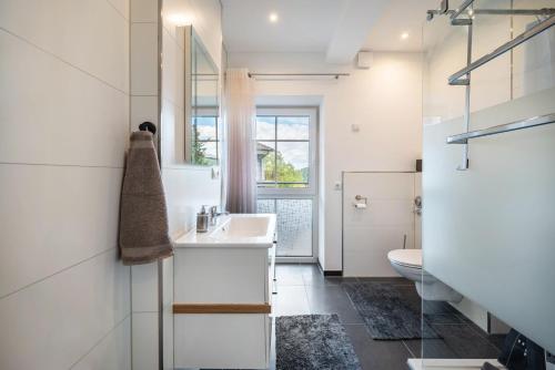 a white bathroom with a sink and a toilet at Haus Burgblick in Badenweiler