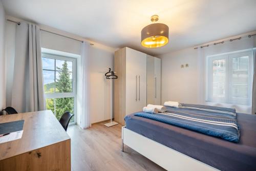 a bedroom with a bed and a desk and a window at Haus Burgblick in Badenweiler