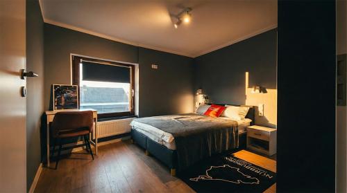 a bedroom with a bed and a desk and a window at GT Nord Hof in Müllenbach