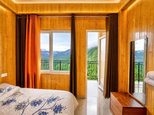 a bedroom with a bed and a balcony with mountains at The Amber Retreat - Best Property In Mussoorie #Luxury Rooms #Balcony #Parking #Budget Friendly #Mountain View #Restaurant #Couple Friendly in Mussoorie