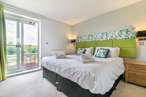 a bedroom with a large bed with a large window at 4 Bed in Winnards Perch oc-t29558 in Saint Columb Major