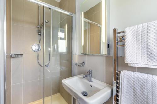 a bathroom with a shower and a sink and a mirror at 4 Bed in Winnards Perch oc-t29558 in Saint Columb Major
