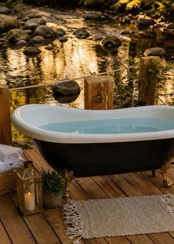 a bath tub sitting on a wooden deck next to the water at Villa Boutique 1880-Romantic Historic Boutique Hotel with Outdoor Jacuzzi in San Salvador