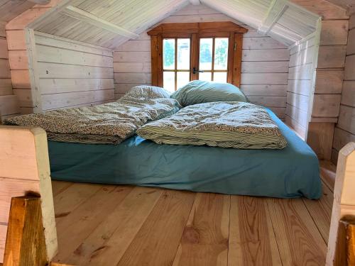two beds in a room in a wooden house at Relax nad Narwią u Oli Pawła in Chmielewo