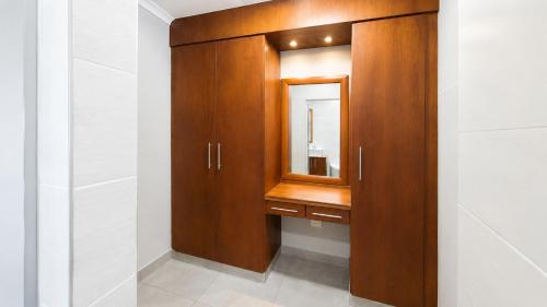 a bathroom with a wooden cabinet with a mirror at Giney's View 8 Unit in Vilanculos