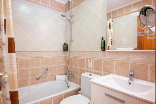 a bathroom with a toilet and a sink and a tub at Ona Los Claveles in Los Cristianos