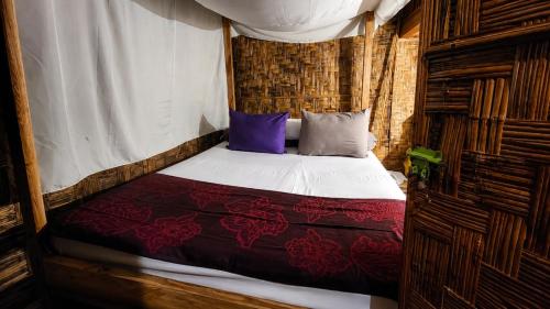 a bed in a room with a canopy at Pondok Wisata Noah in Likupang