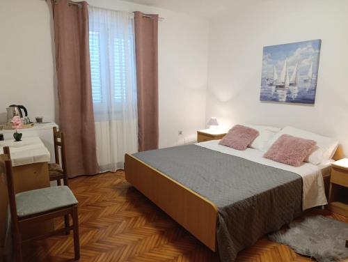 a bedroom with a bed and a desk and a chair at Rooms with a parking space Krk - 5371 in Krk